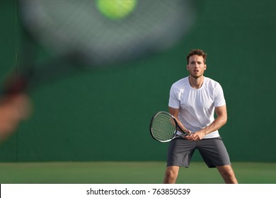 Tennis Player Focused On Other Player Hitting Ball With Racket On Court. Men Sport Athletes Players Playing Tennis Match Together. Two Professional Tennis Players On Hard Outdoor Court During Game.