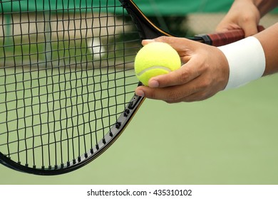 Tennis player holding racket and ball in hands - Powered by Shutterstock