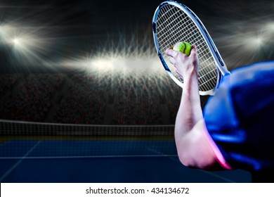 Tennis Player Holding A Racquet Ready To Serve Against Digitally Generated Image Of Blue Tennis Court Illuminate By Spotlight