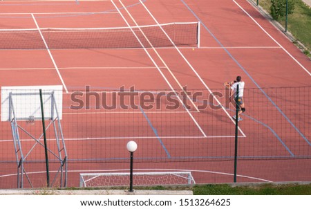 Similar – Leerer Tennisplatz mit Ballwagen und leuchtend rotem Belag