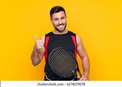 Tennis player man over isolated yellow wall with thumbs up because something good has happened - Shutterstock ID 1674079078