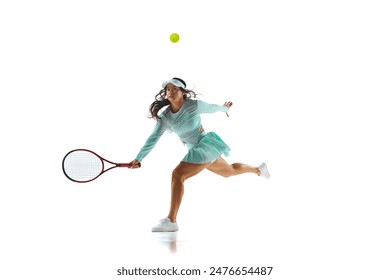 Tennis player in mint-green dress captured mid-lunge, as she prepares to hit the ball against white studio background. Concept of professional sport, championship, active lifestyle, tournament. Ad - Powered by Shutterstock