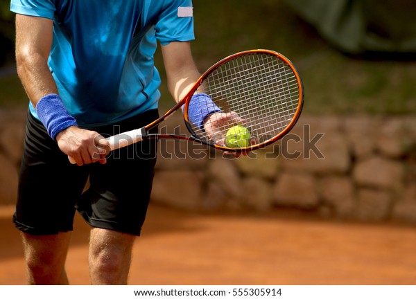 A tennis player prepares to serve a tennis ball\
during a match