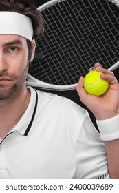 Tennis player with racket closeup. Man athlete playing isolated on black background.