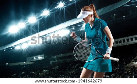 Tennis player with racket. Woman athlete celebrating victory on grand arena background after good play.
