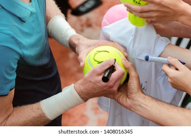 Tennis Player Signs Autograph On A Tennis Ball After Win, Closeup Photo Showing Tennis Balls And Hands, Man Making Signature.