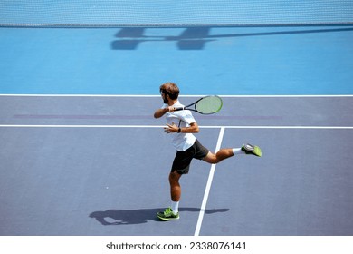 Tennis player training on a professional tennis court. - Powered by Shutterstock