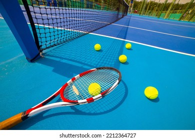 Tennis racket and tennis ball  on hard blue court