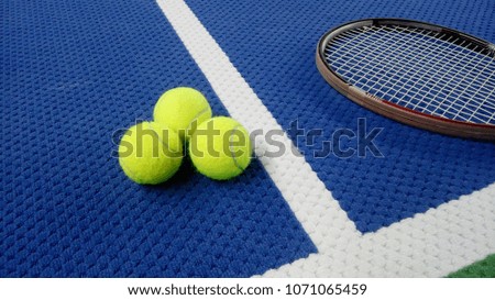 tennis racket with tennis balls in an indoor tennis center