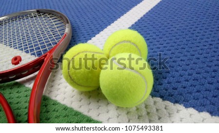 tennis racket with tennis balls in an indoor tennis center