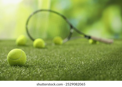 Tennis racket and balls on green artificial grass, selective focus - Powered by Shutterstock