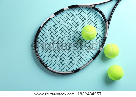 Tennis racket and balls on light blue background, flat lay. Sports equipment