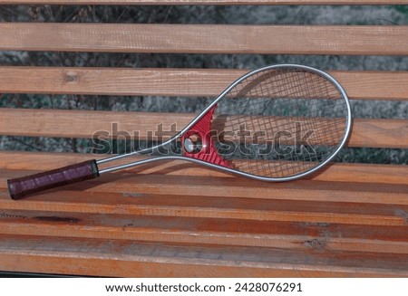 Tennis racket on a park bench
