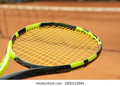 Tennis Racquet Against Clay Court, Close Up