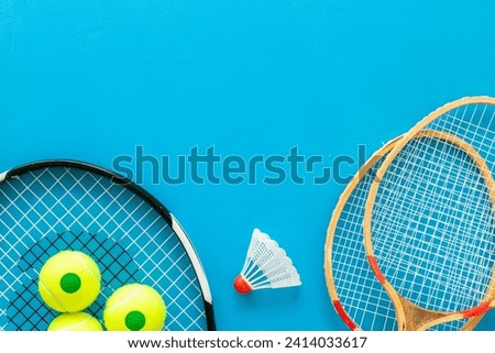 Tennis racquet with balls and badminton racket, top view. Sport games background.