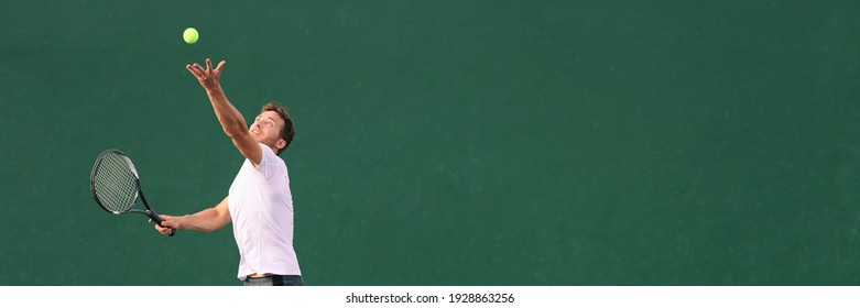 Tennis serve during match. Man tennis player playing throwing ball in the air serving playing on hard indoor court panoramic banner. - Powered by Shutterstock