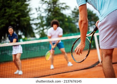 Tennis sport people concept. Mixed doubles player hitting tennis ball with partner standing near net - Powered by Shutterstock