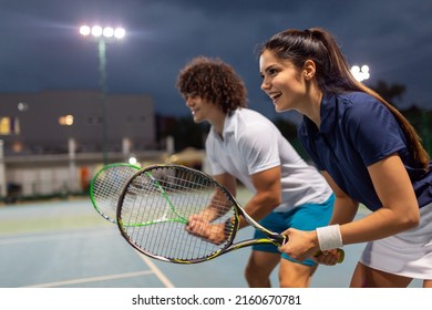 Tennis sport people concept. Mixed doubles player hitting tennis ball with partner standing near net - Powered by Shutterstock