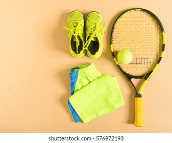 Tennis stuff on cream background. Sport, fitness, tennis, healthy lifestyle, sport stuff. Tennis racket, lime trainers, tennis balls, lime athletic shorts. Flat lay, top view. - Powered by Shutterstock