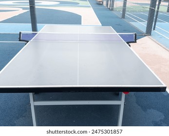 tennis table on the park area around lawn blue white metallic. sun game players, nobody, school yard - Powered by Shutterstock