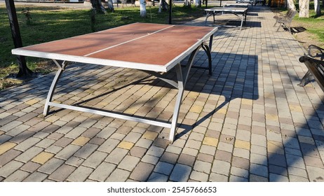 Tennis table on a path in a park, sunny day, no people - Powered by Shutterstock