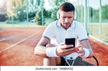 Tennis. Young tennis player take a rest after training, having fun with mobile phone. Sport, recreation concept - Powered by Shutterstock