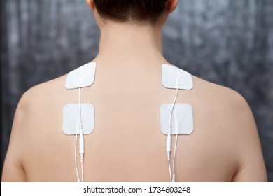 TENS therapy in fibromyalgia treatment - electrodes placed on female patient's shoulders.