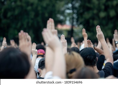 Tens of thousands of Pro-democracy demonstrators attend an anti-government protest at Victory Monument. They're flashes the three-fingers salute. Bangkok Thailand October 21, 2020. - Shutterstock ID 1839154696