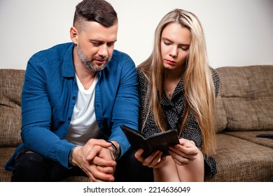 A Tense European Young Married Couple, Wife And Husband, Confused By The Calculation Of Expenses On An Invoice Or Receipt, Do Not Have Money To Pay. Mortgage, Debt-causing Loan, Bankruptcy. Debt