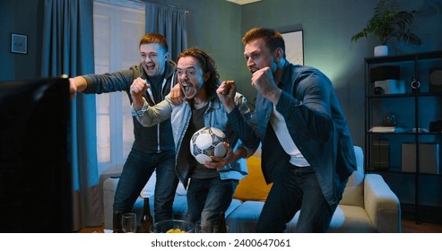 Tensed worried Caucasian male football fans friends staying in front of TV screen in dark living room on vouch and watching match Euro2024.Cheerful men celebrating win. - Powered by Shutterstock