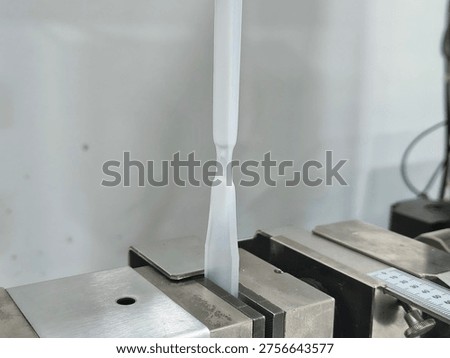 Tensile Strength Testing of Plastic Specimen in Laboratory, Close-up of Universal Testing Machine Gripping Polymer Material for Stress and Strain Analysis in Industrial Quality Control