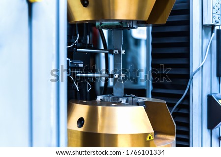 Tensile Testing, automatic tensile strength testing machine with product specimen test in the industrial factory laboratory. Mechanical properties of a material test.