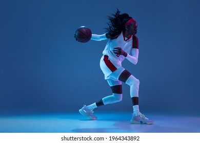 Tensioned. Beautiful african-american female basketball player in motion and action in neon light on blue background. Concept of healthy lifestyle, professional sport, hobby. Woman in sport. - Powered by Shutterstock