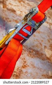 Tensioned Cargo Strap, Orange, With Ratchet Lock, Diagonal Close-up.
