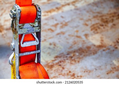 Tensioned Cargo Strap, Orange, With Ratchet Lock, Close-up.