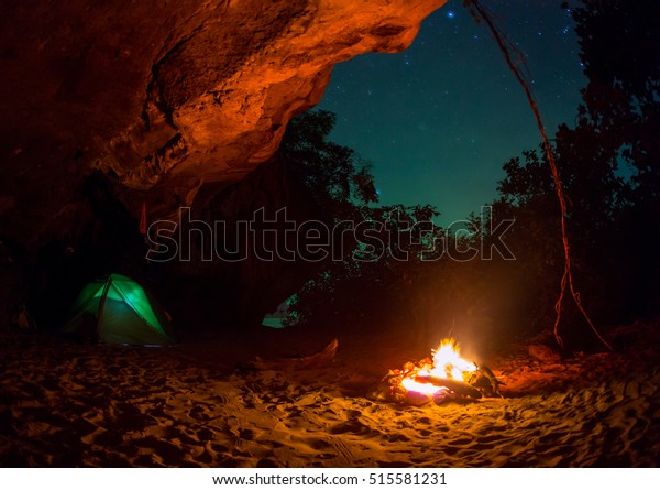 Tent camping car couple romantic sitting by\
bonfire night countryside