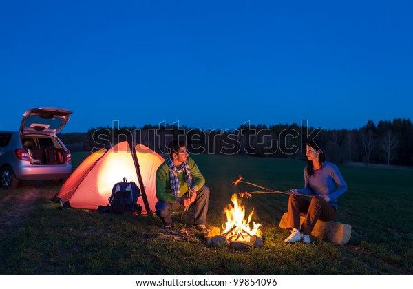 Tent camping car couple romantic sitting by
bonfire night countryside