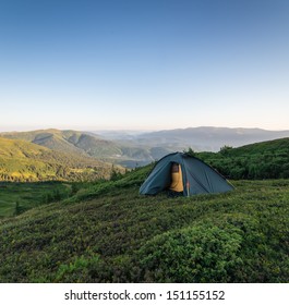 Tent in mountains at sunrise