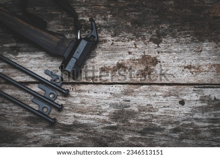 Tent peg nail iron hammer handle is made of ebony wood on old wooden background