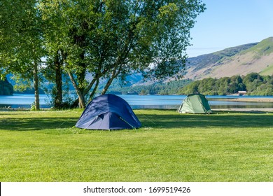 
Tents at the campsite on the green grass on a sunny day. Lake District England - Shutterstock ID 1699519426
