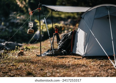 tents pitched on hillsides beside streams of water from waterfalls. hiking bag, hiking shoes on the ground. - Powered by Shutterstock