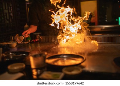 Teppanyaki Chef Preparing Metal Plate With Flaming Fire Ready For Cooking Japanese Cuisine.