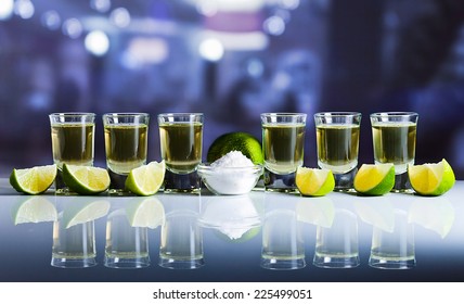 Tequila , Lime And Salt On White Reflexive Table In Bar