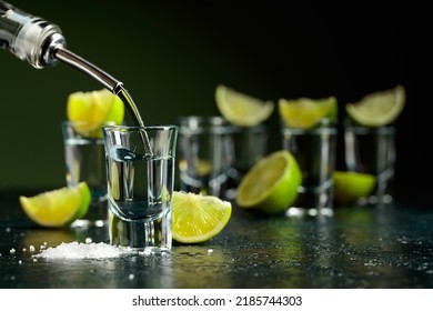 Tequila is poured into a glass. Tequila shots with lime slices and sea salt. - Powered by Shutterstock