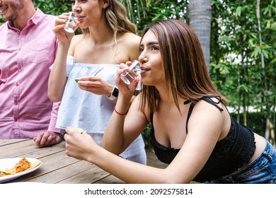 tequila shot, Group of Young latin Friends Meeting For tequila shot or mezcal drinks making A Toast In Restaurant terrace in Mexico Latin America