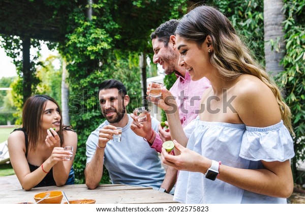tequila shot, Group of Young latin Friends\
Meeting For tequila shot or mezcal drinks making A Toast In\
Restaurant terrace in Mexico Latin\
America