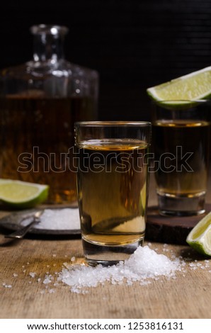 Tequila shot with lime and sea salt on a rustic background. Selective focus.