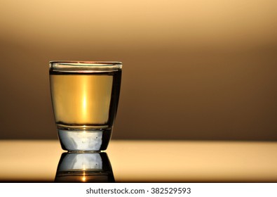 A Tequila Shot In A Tot Glass At Sunset.