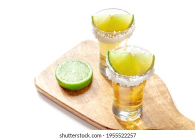 Tequila Shots With Lime Slices On A Wooden Board On A White Background