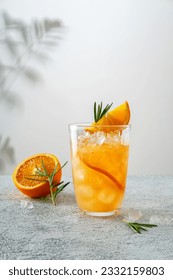 Tequila sunrise cocktail in glass with ice, refreshing summer drink. Cold and refreshing orange punch cocktail with orange slice.  Sunny day shadows.  A refreshing summer cocktail